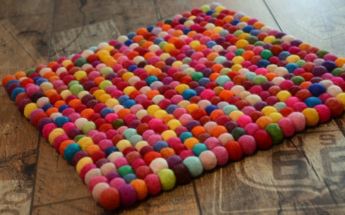 Яркий цветной коврик из помпонов пряжи